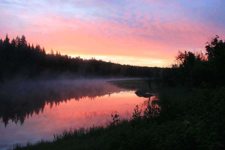 Image of sunrise over Bannock with reflection on water.