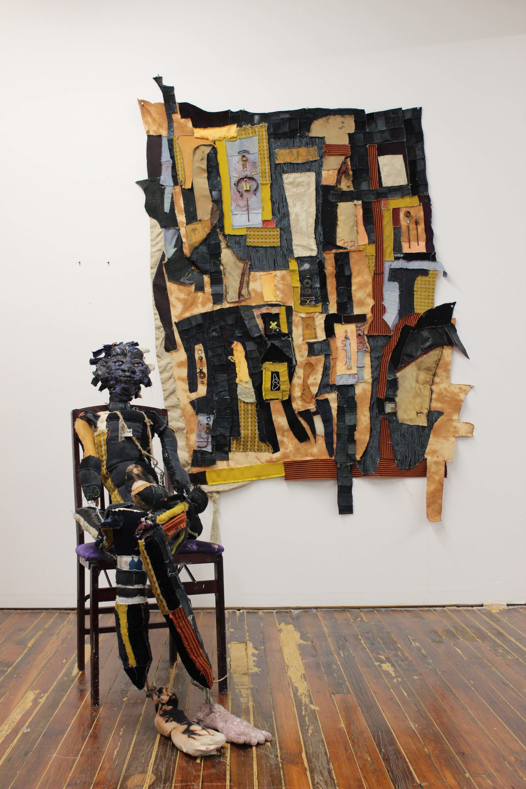 Assemblage of a person sitting in a chair in front of a constructed map.