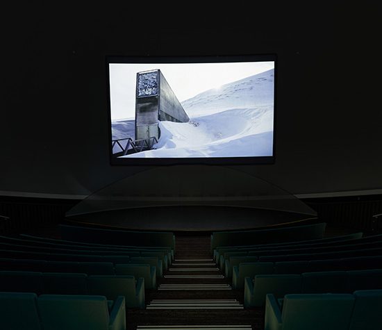 Projection of a building covered in snow, shown in a theatre.