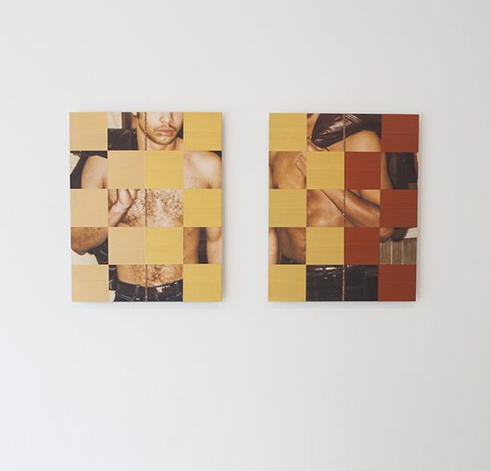 2 photographs hang on a wall. the images are obstructed by gold and tan squares of wax