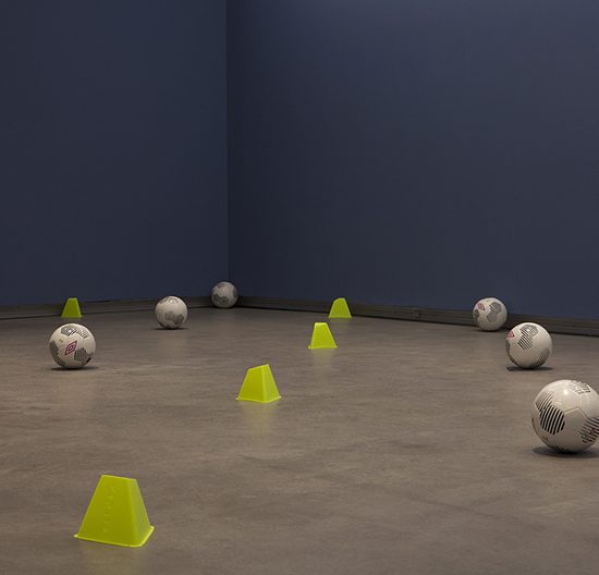 Room with soccer balls and cones scattered on its floor